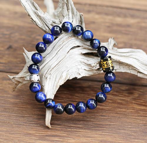 Sobriété, efficacité, pour ce magnifique bracelet de perles de pierre Oeil de tigre couleur bleu outremer moiré du plus bel effet. Orné d'une perle cylindrique de cuivre argenté et d'un cylindre en Onyx gravé