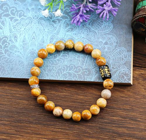 Bracelet-mala de perles de Jaspe jaune qualité supérieure. Avec l'ajout de deux perles de tradition Bouddhiste, dont la fameuse perle-cylindre d'Onyx noir gravée à l'or du Mantra Universel de Protection.