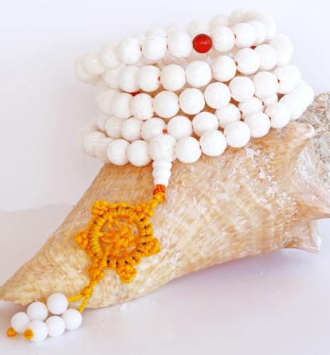 Composé de 108 perles de pierres de Jade blanc avec le pendentif symbolique macramé. Diamètre des perles: 8 mm, longueur totale ouvert: 110 cm, monté sur cordon jaune d'or, fabriqué spécialement au Tibet.