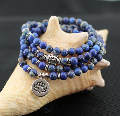 Composé 108 perles de pierres Jaspe bleu avec un portrait de Bouddha et une médaille frappée d'une fleur de lotus symbolique de métal argenté. Ce mala évoque un sourire: celui de la joie de voir les merveilles infinies d'un monde naturel